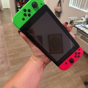 Nintendo Handheld Console with Bright Green and Red Controllers